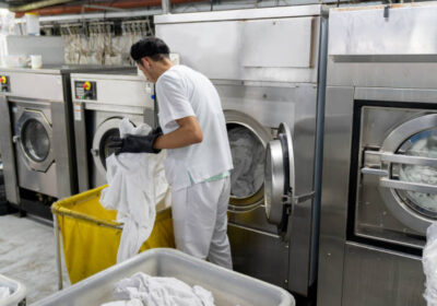 latin american man loading washing machine with dirty bed sheets at picture id1132394261